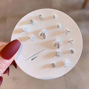 Detail of silver stud earring set with pearls, crystals and bow shapes on display card