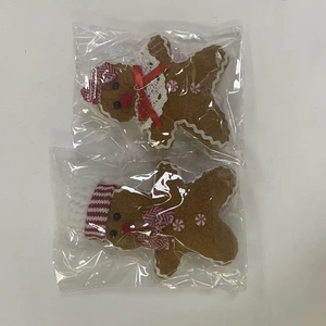 Detail of gingerbread man plush ornaments with knitted hats in plastic packaging