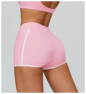 Detailed side view of pink high-waisted yoga shorts with white contrast trim and sleek fit
