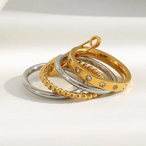 Detailed view of layered stainless steel rings joined by a gold pin with zircon inlay