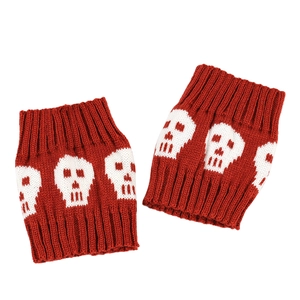 Macro shot of red knit boot cuffs featuring white skull patterns for winter warmth