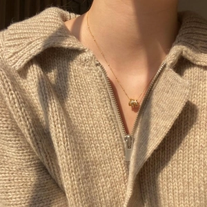 Detail of elegant gold pendant necklace shown on neck for a stylish layering look