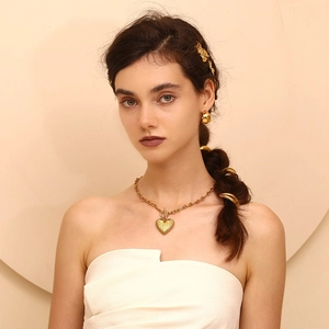 Detailed view of the vintage 18K gold-plated lip-shaped hair tie and heart necklace