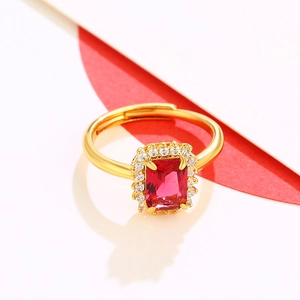 Luxury gold ring featuring a large red gemstone with halo diamonds and adjustable band