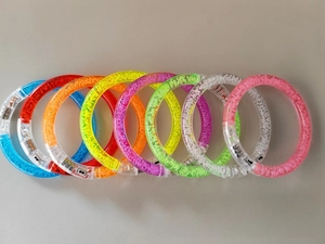 Macro shot of colorful LED acrylic bubble bracelets showing battery packs and switches