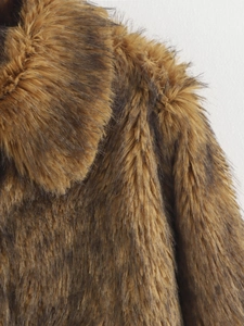 Nahaufnahme der Webpelz-Textur an Kragen und Schulter des braunen Oversized-Mantels
