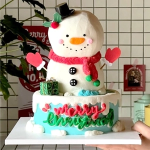 Macro detail of snowman shaped Christmas cake with Merry Christmas cream lettering