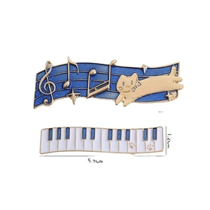 Blue musical cat enamel pins with staff notes and white piano keyboard design