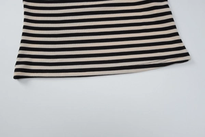 Détail de l'ourlet plat sur un t-shirt rayé à manches longues avec maille noir et beige