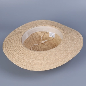Detail of the woven paper straw sun hat interior with inner sweatband and brand tags