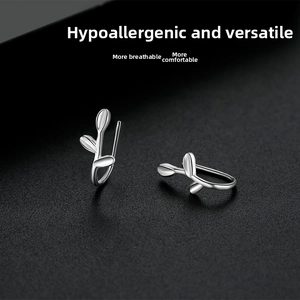Detail of silver ginkgo leaf earrings on black leather, minimalist sterling silver jewelry