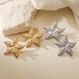 Chic gold and silver star stud earrings with zircon crystals on a satin fabric base