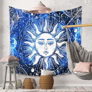 Detail of blue sun and moon tapestry with mandala star patterns on a white wall