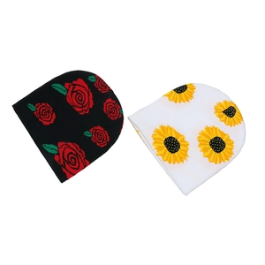 Detail of knitted beanies with red rose and yellow sunflower jacquard floral patterns