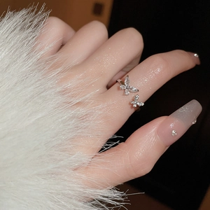 Macro shot of silver zircon butterfly open ring worn on finger with sparkling stones