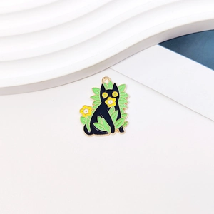 Detail of DIY alloy charm featuring a black cat with green leaves and yellow flowers