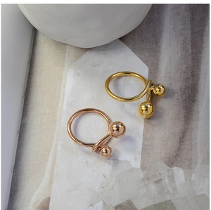Artistic double metal bead geometric rings in gold and rose gold on marble