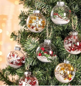 Close-up of clear Christmas tree ornaments filled with berries and pinecones on branches