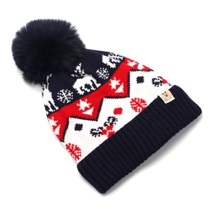 Close-up of knit texture with reindeer pattern and fluffy pompom on Christmas hat