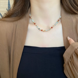 Close-up of colorful natural stone beaded necklace with red and blue accents