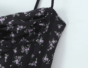 Detail of floral bustier top with corset boning and pleated bust in purple and black