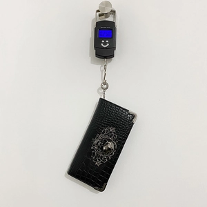 Fashionable long black crocodile leather wallet for women showing weight on a digital scale