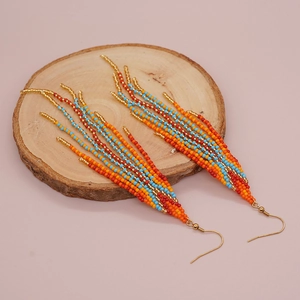 Boucles d'oreilles bohèmes à pompons avec perles colorées et crochets dorés sur bois