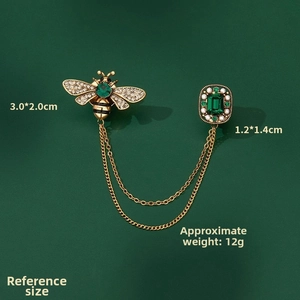 Detail view of vintage bee brooch with green gemstone tassels and precise dimensions