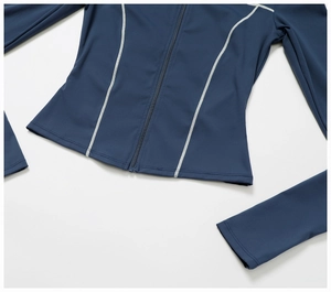 Detail of navy blue zip-up yoga jacket with white contrast stitching and slim fit design