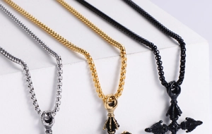 Close-up of diamond pillar cross pendants in silver, gold, and black stainless steel