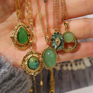 Detailed close-up of 18K gold plated oval natural stone pendants with green gemstones