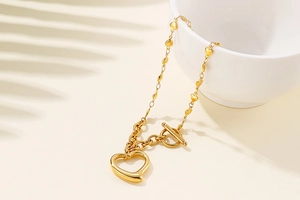 Detail of gold heart pendant necklace with OT toggle clasp and small heart accents