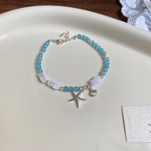 Vue détaillée du bracelet marin avec perles bleues, coquillages et étoile de mer argentée