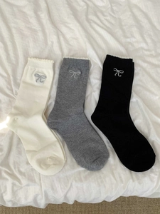 Details von drei Baumwollsocken in Weiß Grau und Schwarz mit Schleifenstickerei und Rüschen