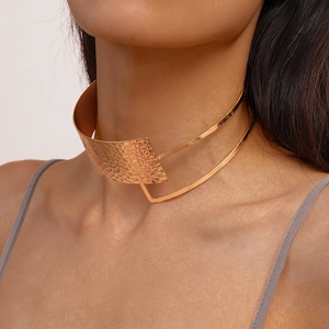 Close-up of gold choker featuring layered metallic pleats and hammered texture finish