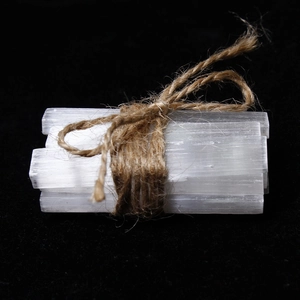 Macro detail of natural white selenite crystal sticks tied with a rustic brown jute rope