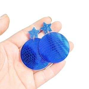 Close-up of blue mirror acrylic disco ball earrings with glitter star details held in hand