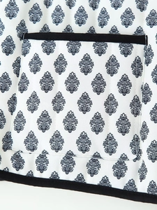 Detailed macro view of quilted cotton fabric with black leaf prints and edge binding
