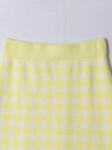 Detailed macro view of yellow and white plaid knit skirt featuring elastic waistband