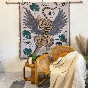 Bohemian winged tiger woven sofa blanket with fringes hanging in a cozy home setting