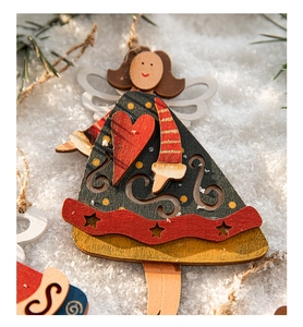 Close-up of a hand-painted wooden Christmas angel ornament with red hearts on a snowy background