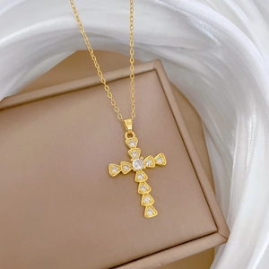 Luxurious gold titanium steel cross necklace with crystal pavé on silk background