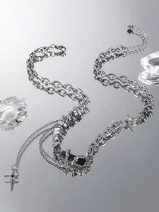 Detail of silver multi-layer chain necklace featuring black gemstone and star pendants