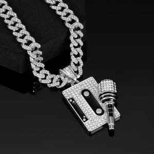 Detail of silver Cuban link necklace with micro-pave microphone pendant on velvet stand