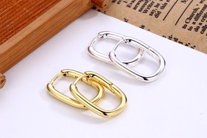 Detailed view of U-shaped gold and silver S925 silver earrings with metallic texture