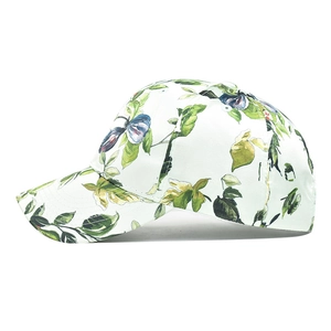 Detail of white cotton baseball cap with green leaves and blue berry floral print