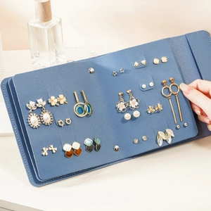 Portable blue leather earring storage book with multi-page design for jewelry organization