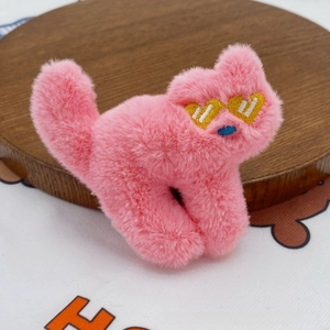 Detailed macro view of a pink plush cat accessory with heart eyes and soft fur texture