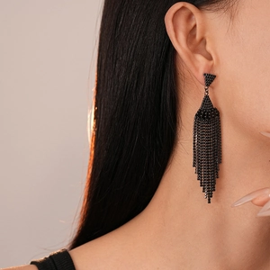 Gros plan de boucles d'oreilles élégantes à pampilles noires sur un mannequin