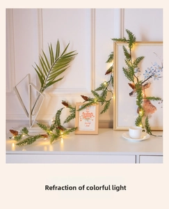 Détail d'une guirlande de pin artificiel avec pommes de pin et lumières LED chaleureuses